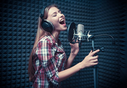 在录音室唱歌的年轻女子图片