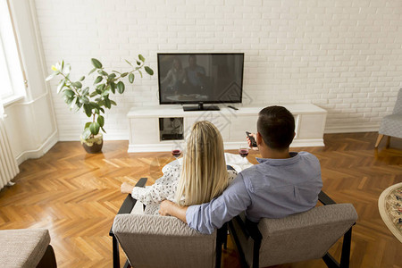情侣在客厅看电视的背影背景图片