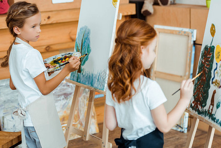 看着艺术学校画布上的孩子绘画的可爱孩子有图片