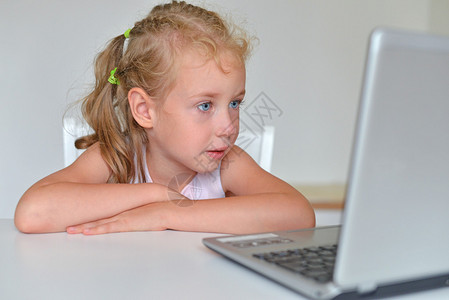 小女孩在电脑前看卡通片图片