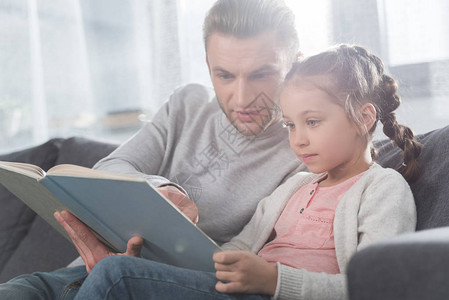 英俊的父亲在家教女儿读书图片