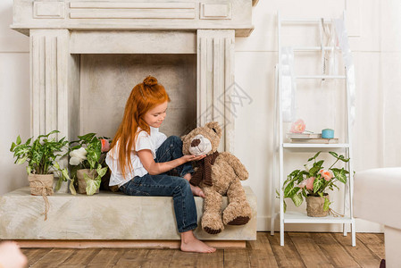 可爱的小女孩在家中玩泰迪图片