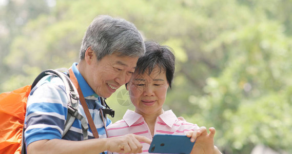 亚裔老夫妇去乡村旅行并使用图片