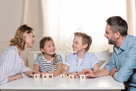 微笑的家庭坐在桌边用木图片
