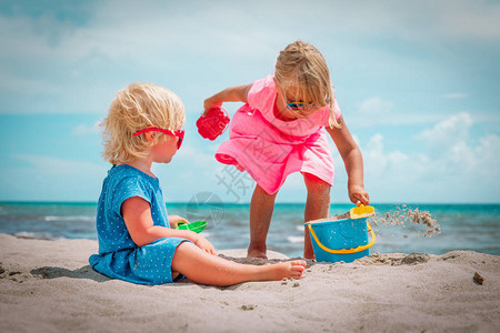 孩子们在夏季沙滩上玩沙子图片