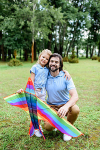 英俊的快乐的父亲和女儿与风筝看图片