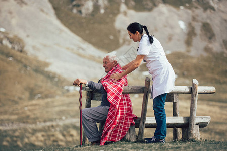 护士帮助老年人在户外散落图片