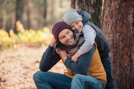 父亲和儿子在秋林中拥抱着快乐图片