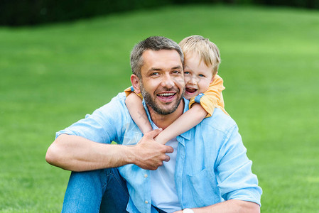 快乐的父亲和儿子在公园的相机图片