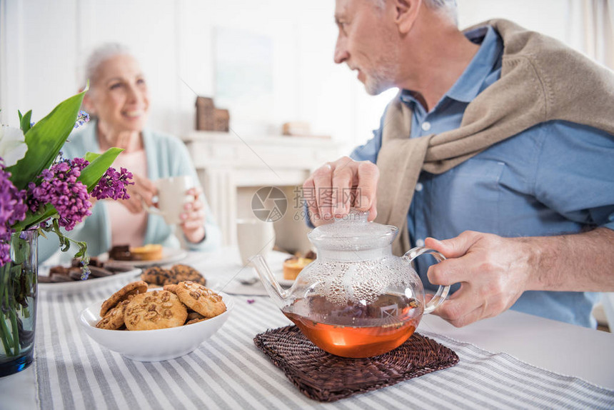 在家吃早餐时微笑的老年夫妇喝茶图片