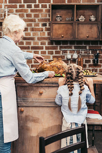 快乐的外祖母和孙女还有美味的火鸡在图片