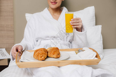 在酒店房间休息时在床上吃早餐的浴袍女被射中身图片