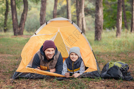 快乐的父亲和儿子躺在帐篷里图片