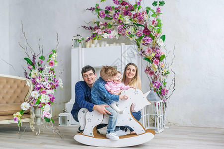 幸福的四口之家坐在带花的房间里图片