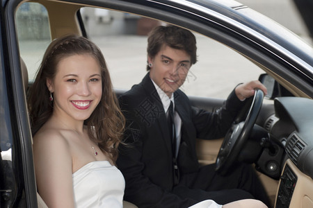 一对浪漫情侣坐在车里时笑着微笑图片