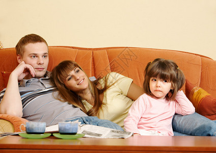 快乐的情侣和女儿在沙发上图片