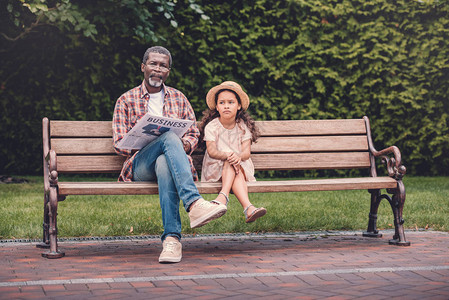 坐在公园长椅上的美国孙女和外祖父图片