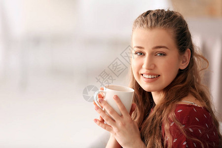 背景模糊的年轻女子喝茶图片