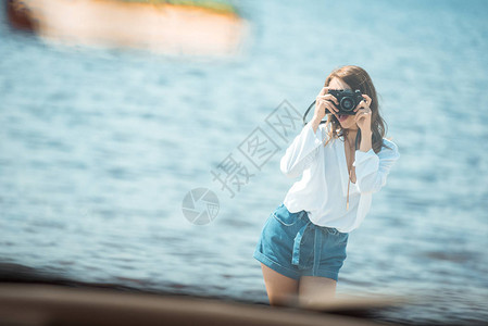 女孩在公路旅行中拍摄海上附背景图片
