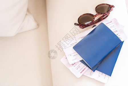 近视的护照和沙发上贴有机票和墨镜的太阳镜图片