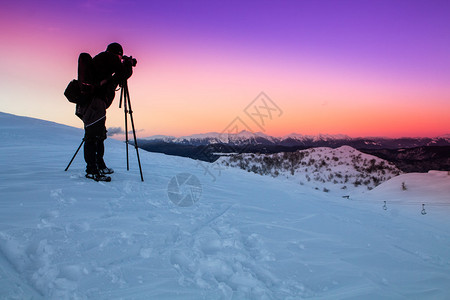 自然摄影师在山上拍照图片