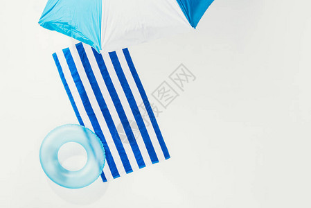 沙滩伞条纹毛巾和充气环的顶部视图图片