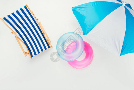 沙滩伞条纹沙滩椅和在白色上隔离的充气环的顶视图背景图片