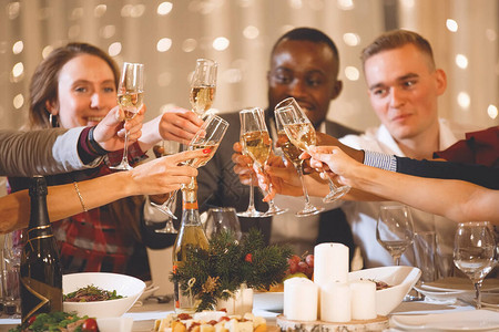 一群跨国朋友在节日餐桌上用香槟杯庆祝圣诞节图片