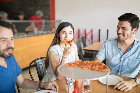 与餐厅的男朋友一起享受披萨切片的有吸引图片