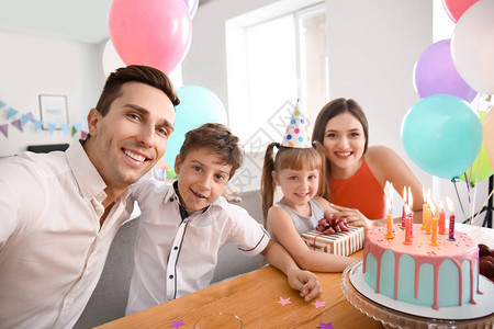 年轻男人在家庆祝女儿生日时带着自拍和图片