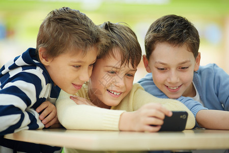 三个男孩在智能手机上网图片