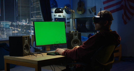 一名青年男子在戴VR头盔时使用计算图片
