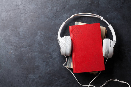 音频书集概念石板上的耳机和书本您的顶端图片