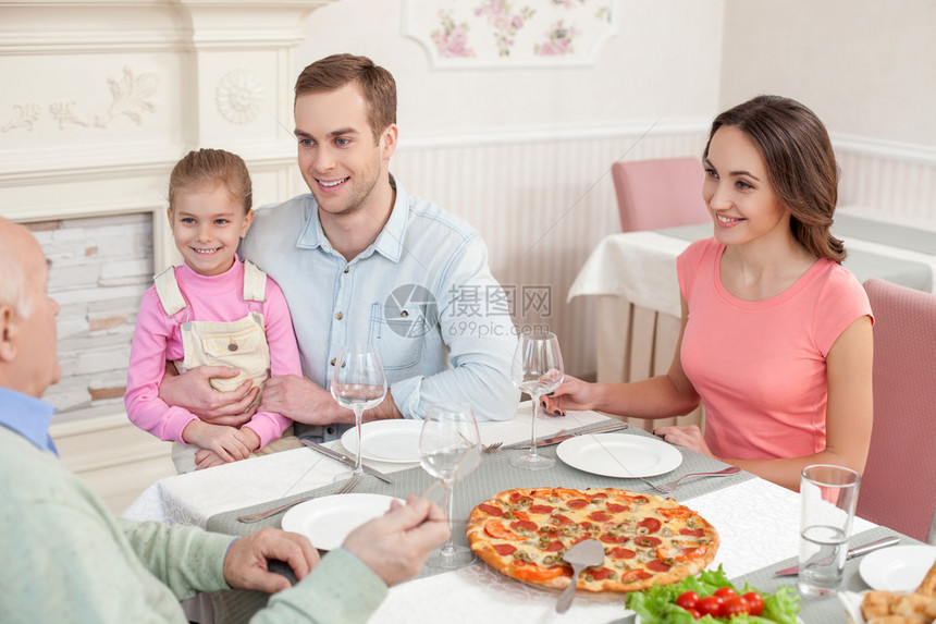 快乐的家人在餐厅一起用餐他们坐在桌旁微笑着已婚夫妇带着孩子高兴图片