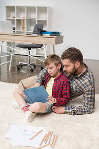 在家办公室和儿子一起读书的商图片