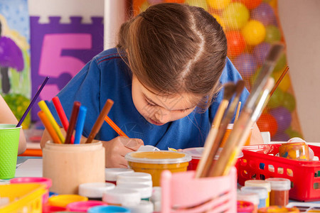 小学生在艺术学校课上画孩子在桌子上用颜料画幼儿园里的男孩和女孩绘画教育培养孩子的创造能力背景图片