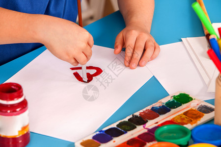 艺术学校课上小学生画心的手孩子在桌子上用颜料画母亲节假期儿童俱乐部的孩子工艺绘画教育培养孩背景图片
