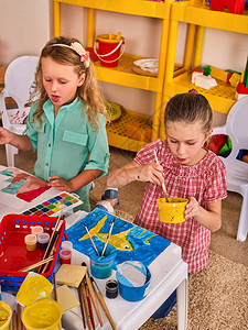 小学生在艺术学校课上画孩子在桌子上用颜料画孩子们在幼儿园混合水彩绘画教育背景图片