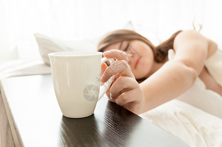 美女在床上喝咖啡的近身图片