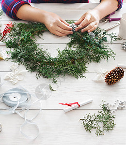 创意DIY工艺爱好制作手工自制圣诞饰品和枞树花环女人休闲图片