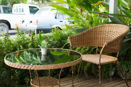 花园外的玻璃桌和藤编椅装饰背景图片