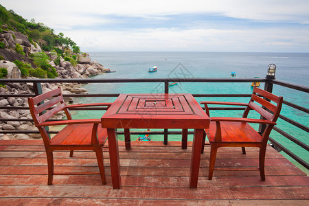 靠近海边的餐厅阳台上的椅子桌子图片