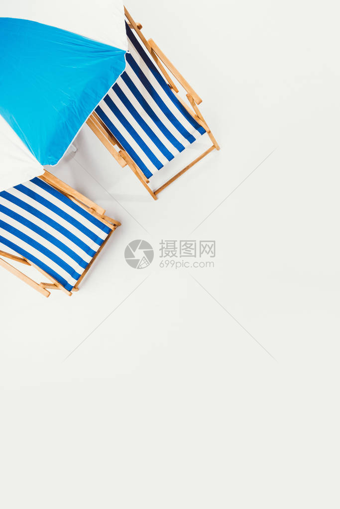 海滩雨伞和条纹沙滩椅的顶部外观它们被隔图片