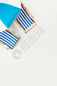 海滩雨伞和条纹沙滩椅的顶部外观它们被隔图片
