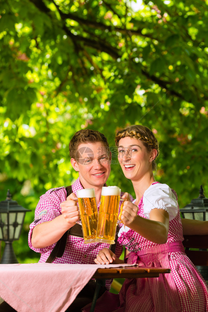 夏日坐在啤酒花园的快乐情侣享受啤酒图片