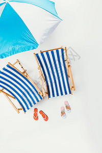 海滩雨伞条纹海滩椅和白色孤图片