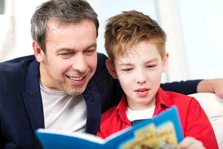 快乐的父亲和儿子花时间读书爸在看图片