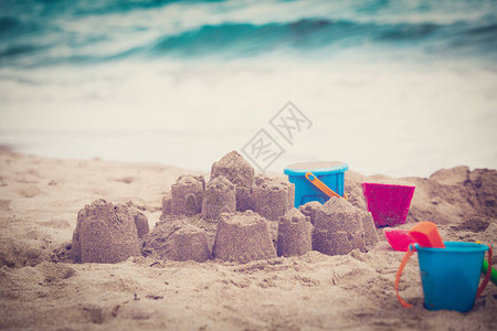 热带海滩上的玩具和沙堡度假概念图片