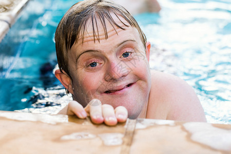 游泳池里残疾男孩的近图片