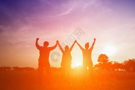 美满家庭在日落时举高手的太图片